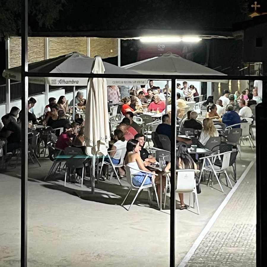 La terraza de El Colorao llena de gente una noche de verano, con las sombrillas abiertas