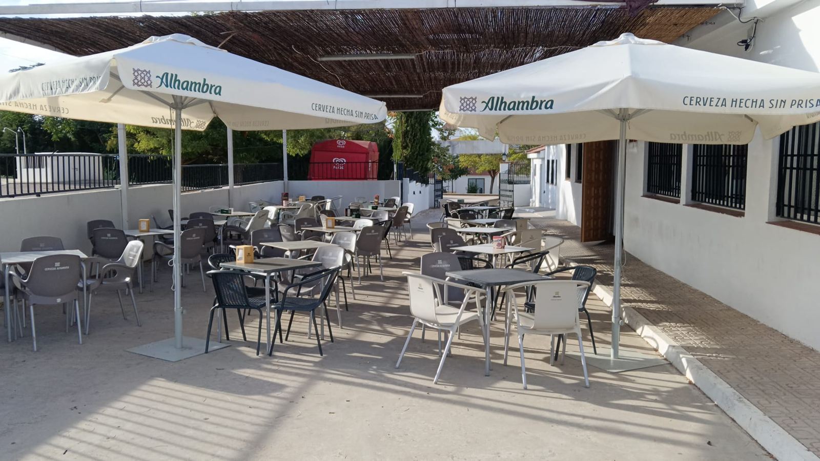 Terraza a la sombra del cañizo, con sombrillas, mesas y sillas